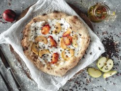 Pizza dolce con crema di mascarpone, fette di mela e pesca caramellate con scaglie di cioccolato image