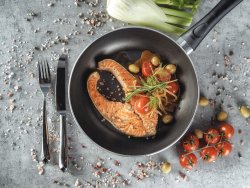 Salmone in padella con olive, pomodorini freschi, finocchio, aglio e salsa di vino bianco image