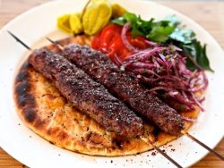Kebab Adana servit cu sos de ardei lipie și cartofi prăjiți image